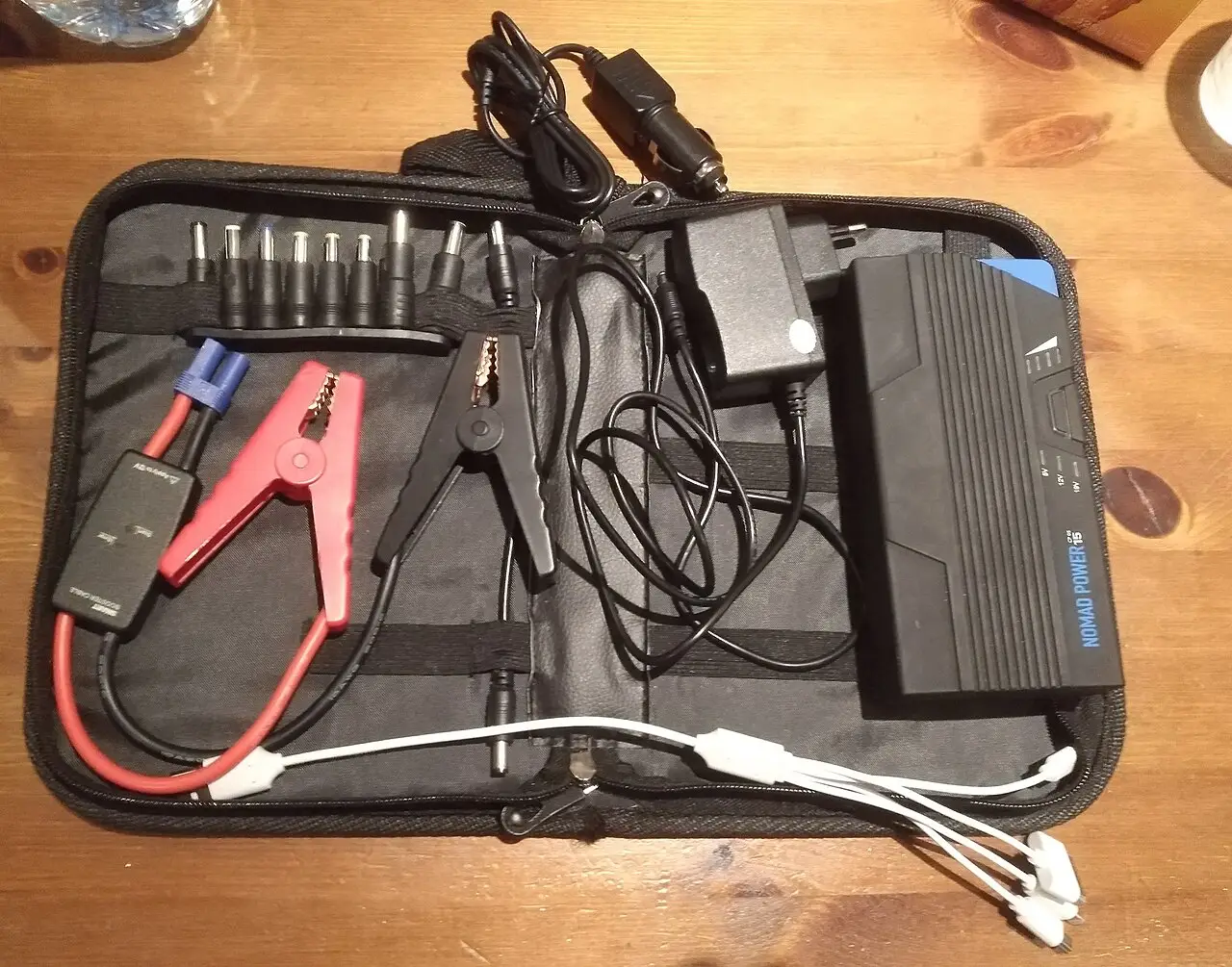 how to choose a portable jump starter kit with red and black clamps, chargers, adapters, and a carrying case.